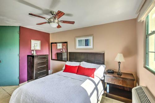 a bedroom with a bed with red pillows and a ceiling fan at Tropical Puerto Rico Penthouse Waterpark On-Site! in Loiza