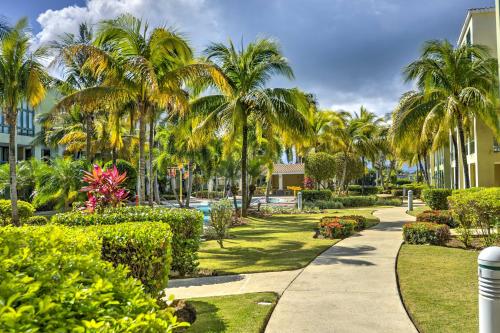 a walkway through a resort with palm trees and bushes at Tropical Puerto Rico Penthouse Waterpark On-Site! in Loiza