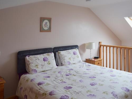 a bedroom with a bed with purple flowers on it at Valley View - 29530 in Scotforth