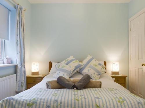 a bedroom with a bed with blue and white pillows at Bards Well in Stratford-upon-Avon
