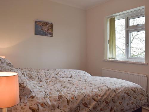 1 dormitorio con cama y ventana en Ty Howton, en Clydach