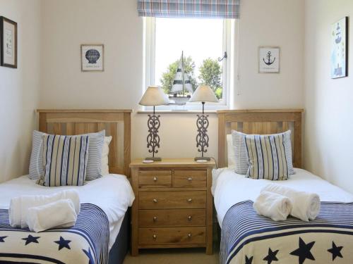 スカーバラにあるHarrowby Cottageのベッドルーム1室(ベッド2台、窓付)