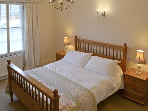 a bedroom with a bed with white sheets and a window at Varley House in Saxmundham