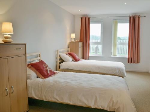 a bedroom with two beds and a window at Waters Edge in Llanelli