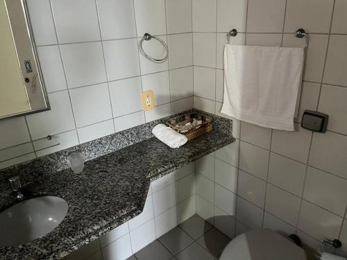 a bathroom with a toilet and a sink and a towel at Apartamento 3 quartos Beira Mar in Anchieta