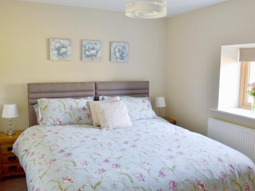 1 dormitorio con 1 cama grande con flores rosas en Holgates Granary en Pendleton