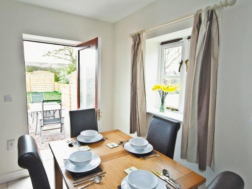 a dining room with a table and chairs and a window at Wisteria Cottage - E5094 in Chapel Saint Leonards