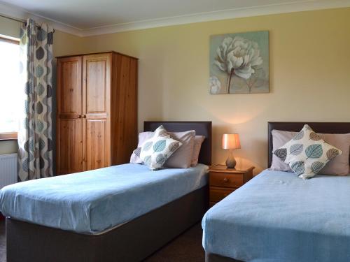 a bedroom with two beds and a dresser at The Lodge in Brandesburton