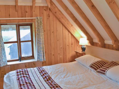 1 dormitorio con cama y ventana en Walnut Tree Cottage en Fordingbridge
