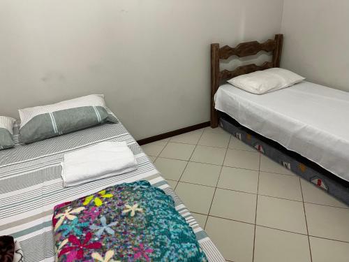 a bedroom with two beds and auggage at Apartamento 3 quartos Beira Mar in Anchieta