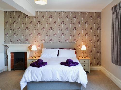シェリンガムにあるMagnolia Lodgeのベッドルーム1室(紫色の枕が付いたベッド1台付)