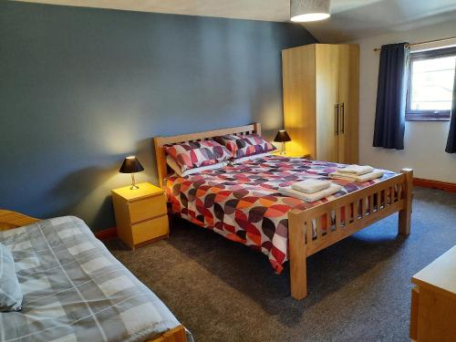 a bedroom with a bed and two night stands and two lamps at Wickhams View in Keswick