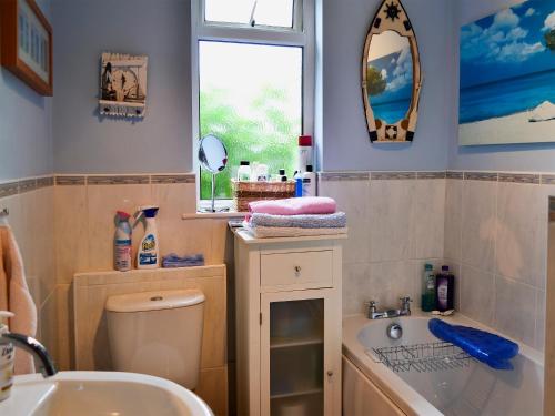 a bathroom with a sink and a toilet and a mirror at Casa Nostro - 27825 in Wooler