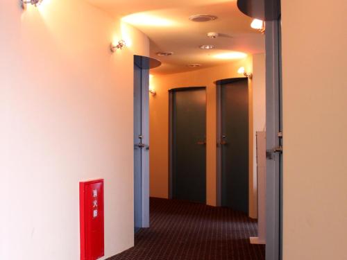 a hallway with four elevators and a red box at HOTEL LiVEMAX BUDGET Korakuen in Tokyo
