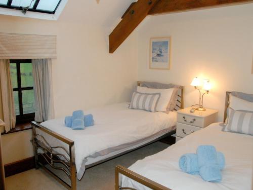 2 Betten in einem Zimmer mit blauen Handtüchern darauf in der Unterkunft Orchard House in Parkham