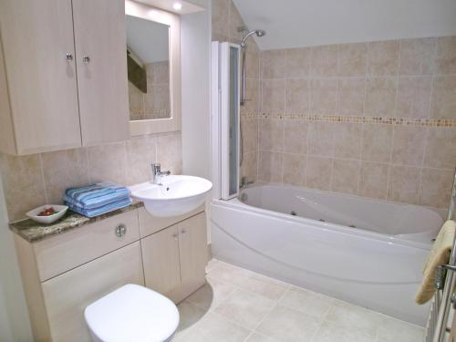 ein Badezimmer mit einem Waschbecken, einer Badewanne und einem WC in der Unterkunft Orchard House in Parkham