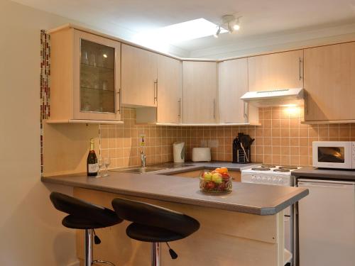 a kitchen with a counter with a bowl of fruit on it at Cameron Lodge Cottage in Innellan