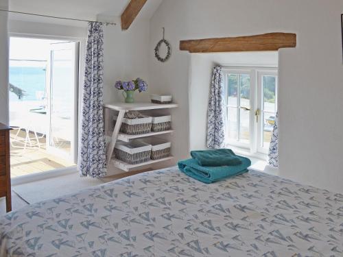 um quarto com uma cama com uma almofada azul em Chy An Ky Bras em Porthallow