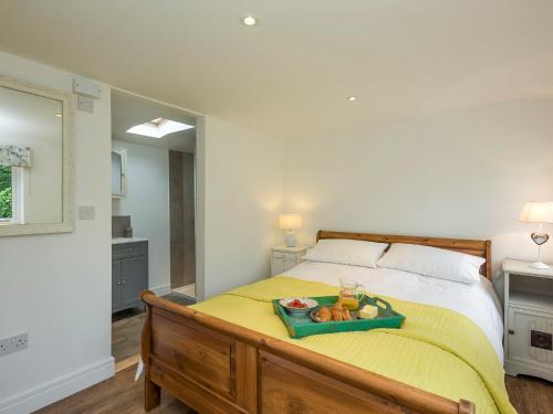 a bedroom with a bed with a tray of fruit on it at Barn Owl Lodge in Stoke Holy Cross