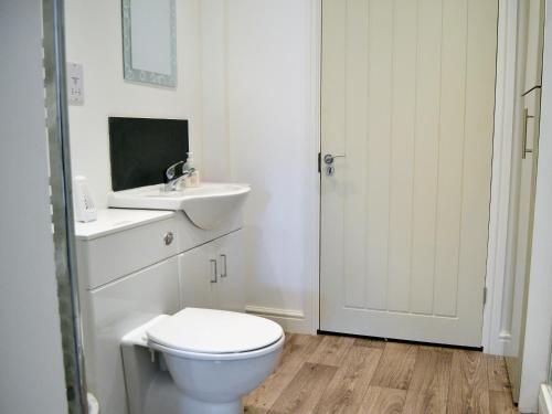 biała łazienka z toaletą i umywalką w obiekcie Little Orchard w mieście Dursley