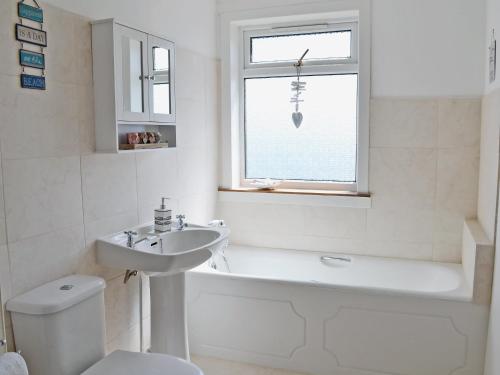 a bathroom with a sink and a toilet and a bath tub at The Lucken in Auchmithie