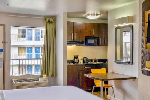 a kitchen with a bed and a table in a room at Studio 6-San Antonio, TX - Airport in San Antonio