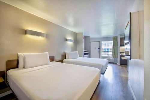 a hotel room with two beds and a bathroom at Studio 6-San Antonio, TX - Airport in San Antonio