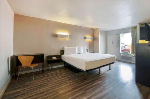 a bedroom with a bed and a table and a chair at Studio 6-San Antonio, TX - Airport in San Antonio