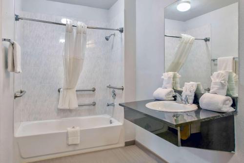 a white bathroom with a sink and a bath tub at Studio 6-San Antonio, TX - Airport in San Antonio