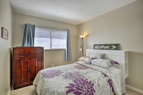 a bedroom with a bed and a dresser and a window at Walk to Beach and Dining Sunny St Pete Condo! in St Pete Beach