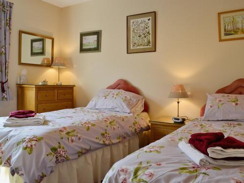 a bedroom with two beds and two lamps at Ferry View in Oban