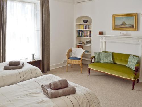 sala de estar con 2 camas y sofá verde en St Marys House, en Penzance
