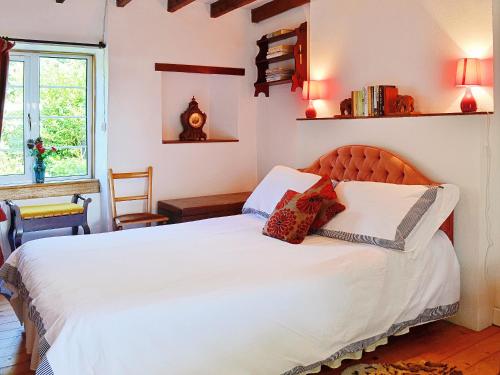 um quarto com uma cama grande e lençóis brancos em The Cottage em Saint Cyrus