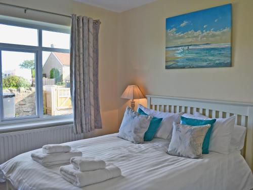 a bedroom with a bed with towels on it at Wayside in Beadnell