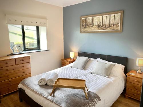 a bedroom with a large bed with a bench on it at Red Kite Cottage in Llangunllo