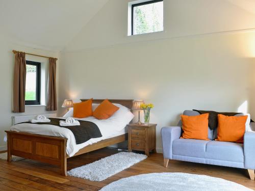 a bedroom with a bed and a blue couch at Dolgoed House in Llangadog