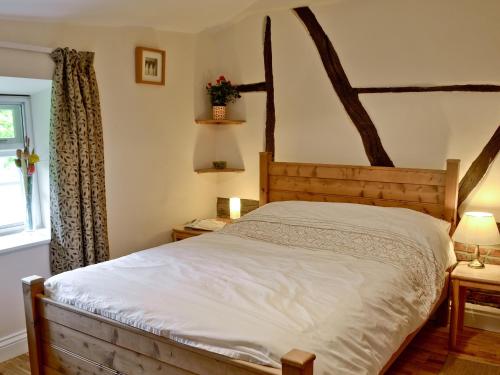 a bedroom with a wooden bed and a window at The Old Post Office in Fordingbridge