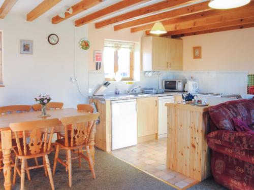a kitchen and dining room with a table and a couch at Porth View in Saint Mawgan
