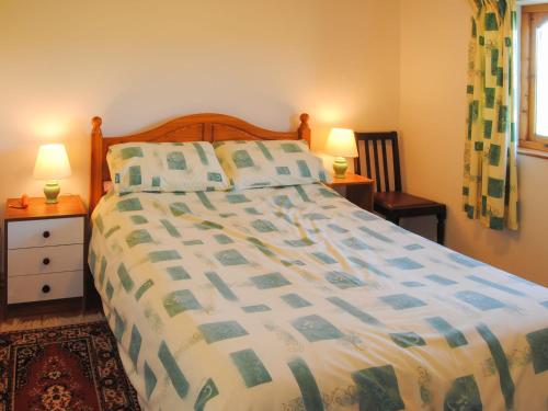 a bedroom with a large bed and two lamps at Porth View in Saint Mawgan