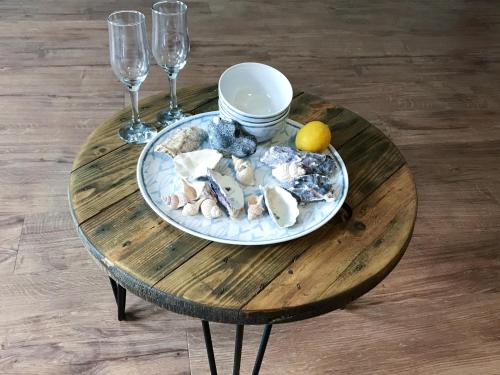 una mesa de madera con un plato de ostras y copas de vino en Foal Barn Cottages - The Smithy - Spennithorne, en Middleham