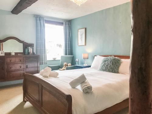 1 dormitorio con 1 cama grande y toallas. en Foal Barn Cottages - The Smithy - Spennithorne, en Middleham