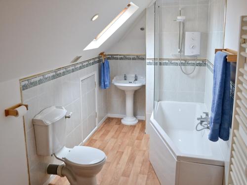 a bathroom with a toilet and a sink and a bath tub at Seasands in Sheringham