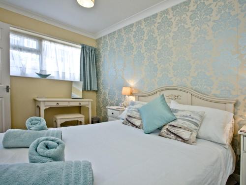 a bedroom with a large bed with blue walls at Turnstone - 2 Linden Court in Brixham