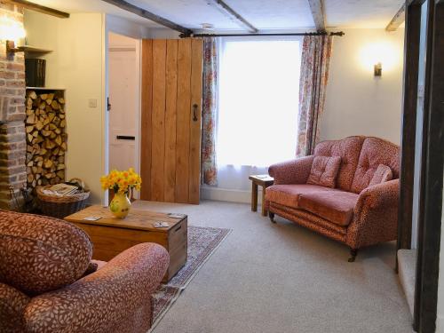 uma sala de estar com duas cadeiras e uma mesa em The Cottage em Broadstairs