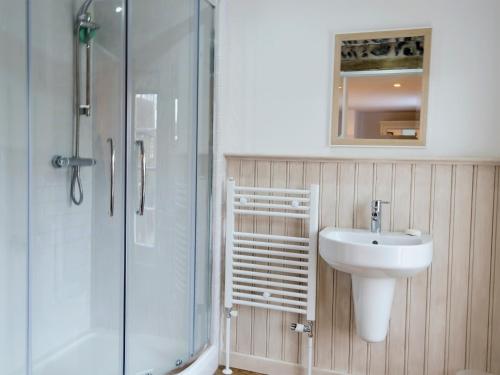 y baño con lavabo y ducha acristalada. en The Cottage en Broadstairs