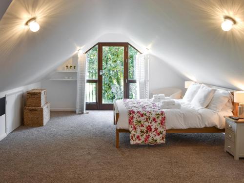 a white bedroom with a bed and a window at The Old Smithy in Kea