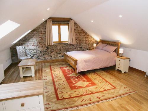 um quarto com uma cama num sótão em The Street Farm Barn em Drayton