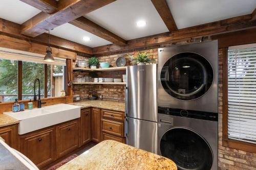 La cuisine est équipée d'un réfrigérateur en acier inoxydable et d'un évier. dans l'établissement Stilly River Haus - Hot-tub-Firepit-Fireplace, à Granite Falls