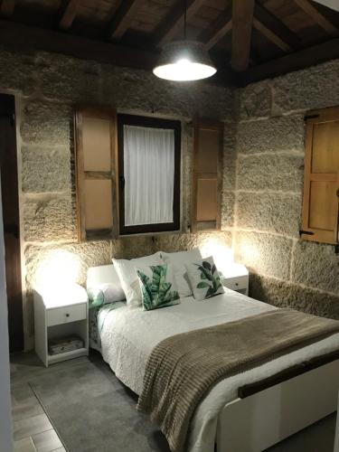 ein Schlafzimmer mit einem Bett mit zwei Nachttischen in der Unterkunft Casa Escuela Trasmiras 