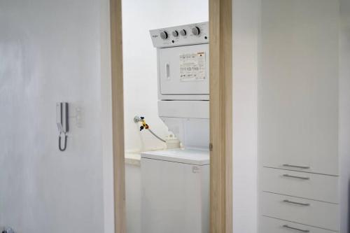 een keuken met een fornuis en een witte oven bij Moderno apartamento en zona urbana de Santiago. in Santiago de los Caballeros